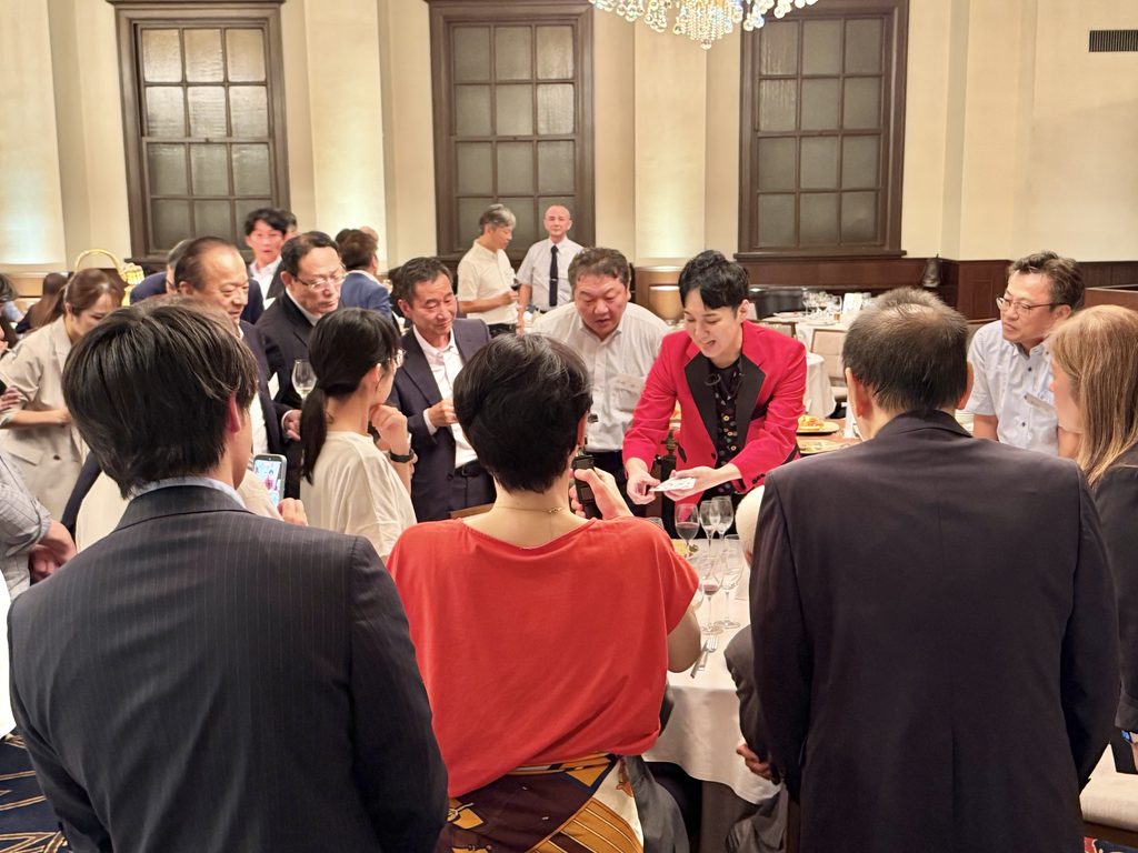 旧桜ノ宮公会堂の企業パーティーでカードを見せながらマジックを披露するMASA