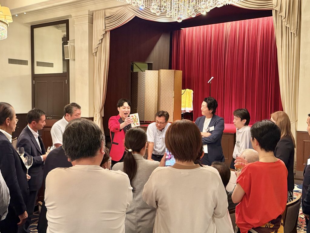 生命保険会社様のパーティーでテーブルマジックに驚き笑顔を見せるお客様